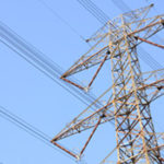 manitoba hydro wires on hydro tower against a blue sky. Single tower in view.