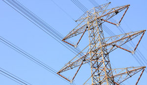 manitoba hydro wires on hydro tower against a blue sky. Single tower in view.